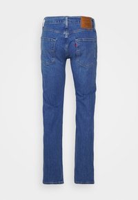 Modré džíny z denimu s rovno střiženým designem, s dvěma zadními kapsami, světlými vybledlými znaky a hnědou koženou značkovou nášivkou v pase.