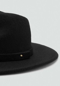 Sombrero de fieltro negro de lana con ala ancha y un sutil detalle dorado en la banda, que muestra una textura suave y un diseño sencillo.