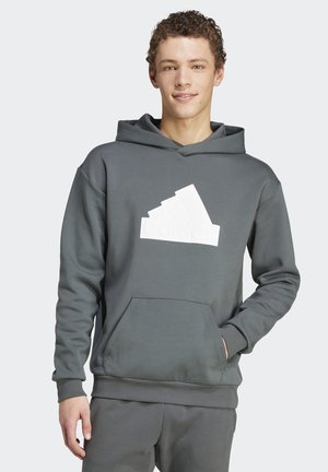 Sudadera gris hecha de una mezcla de algodón que presenta un bolsillo canguro y un prominente logo blanco de Adidas en el pecho.
