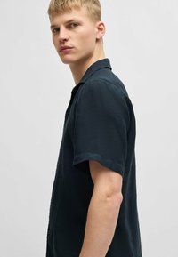 Korteblauwe shirt met korte mouwen, gemaakt van lichte stof. Voorzien van een verspreide kraag en knoopsluiting. Glad oppervlak, relaxed fit.