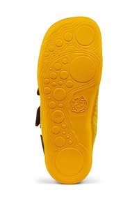 Semelle en caoutchouc jaune d’une chaussure d’enfant avec des motifs circulaires texturés, une icône de visage souriant et la taille 28 embossée.