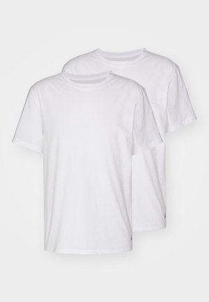 Dve bijele pamučne majice, kratki rukavi, okrugli izrez, bez uzoraka, s malim logom blizu šava s lijeve strane.