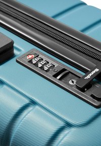 Harde turquoise koffer met een gestructureerd oppervlak, voorzien van een zwart combinatie-slot, rits en TSA-slot voor beveiliging.