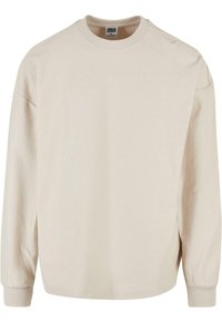 Beige geribbelde sweatshirt met lange mouwen en een ronde halslijn, met verlaagde schouders en geribbelde manchetten. Zachte textuur en een ontspannen pasvorm.