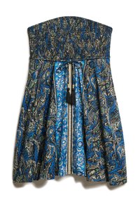 Robe sans bretelles avec un haut smocké, un design fluide, des motifs paisley multicolores en bleu, noir et vert, et un détail de lien et de frange.