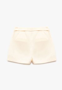 Crème-kleurige shorts met een gestructureerd ontwerp, twee achterzakken en een tailleband met gestructureerde details. Soepele stof, op maat gemaakte pasvorm.