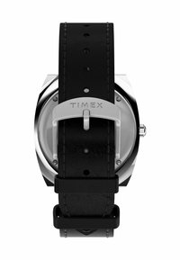 Orologio con cinturino in pelle nera e hardware argentato, con marchio Timex, dotato di cassa rotonda e design minimale.