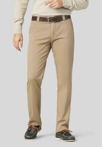 Beige Chinos mit geradem Bein, aus einem Baumwollgemisch gefertigt. Ausgestattet mit einem braunen Gürtel mit einer silbernen Schnalle und akzentuiertem Schuhwerk.