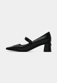 Chaussures à talons Mary Jane en cuir verni noir avec un bout pointu, une sangle à la cheville et un motif crocodile texturé. Design à petit talon carré.