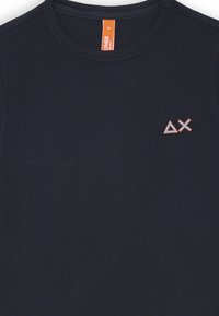 T-shirt blu navy con scollo rotondo, caratterizzato da un logo geometrico ricamato in rosso e arancione sul lato sinistro del petto. Tessuto di cotone liscio.