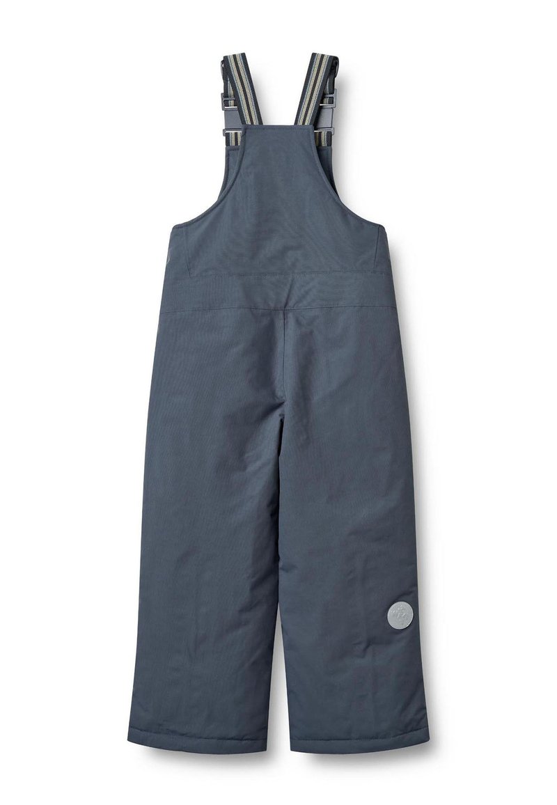 Harmaat, vedenpitävät kangashaalarit, joissa leveät lahkeet, säädettävät raidalliset olkahihnat ja vasemmalla puolella oleva pyöreä logopatchi.