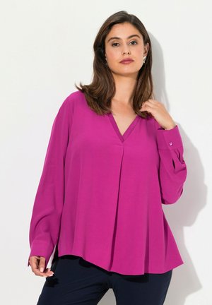 Fuchsia blouse met lange mouwen en een V-hals, geplooide voorkant, manchetaccenten met knopen en een comfortabele pasvorm, gecombineerd met donkere broeken.