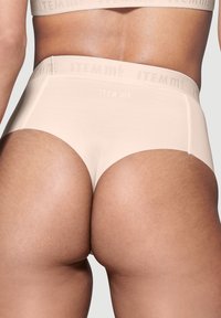 Beige High-Waist-Slip aus glattem Stoff mit nahtlosem Design und elastischem Bund, der mit dem Markennamen Item m6 geprägt ist.