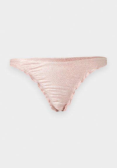 Világos rózsaszín fényes fémbikinialsó oldalán ráncolt részletekkel, tiszta világosszürke háttéren bemutatva.
