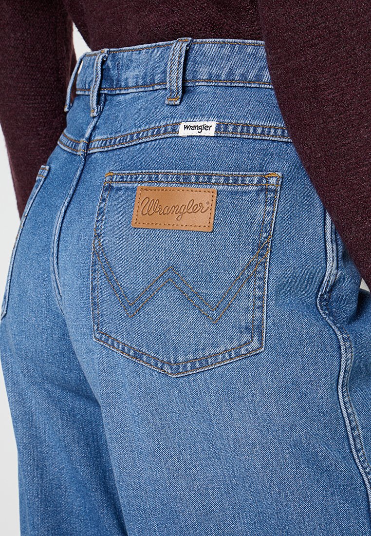 Niebieskie jeansy denimowe z wysokim stanem, z skórzaną naszywką na tylnej kieszeni i charakterystycznym zygzakowatym przeszyciem. Klasyczny pięcio-kieszeniowy fason.
