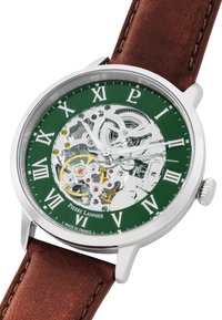 Braunlederarmbanduhr mit einem silbernen Gehäuse, grünem Skelettzifferblatt, römischen Ziffern und freiliegenden mechanischen Bewegungsdetails.