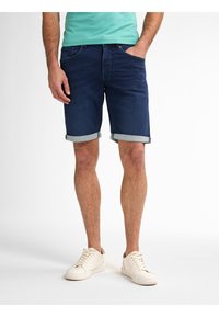 Pantaloni shorts in denim blu scuro, con risvolti, design a cinque tasche, abbinati a sneakers crema e una camicia turchese, con vestibilità comoda.