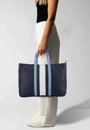 Borsa a spalla navy con accenti a strisce blu chiaro e bianche. Realizzata in materiale testurizzato, presenta due manici superiori e una chiusura con zip.
