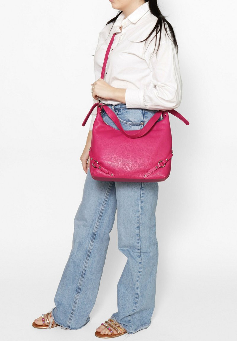 Borsa a tracolla in pelle rosa con finitura testurizzata, dotata di doppi manici, dettagli metallici e un design spazioso. Posizionata su uno sfondo neutro.