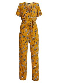 Květinový overal v hořčicově žluté barvě s krátkými rukávy, výstřihem do V, páskem v oblasti pasu a vzorem bílých a modrých květin na texturované tkanině.