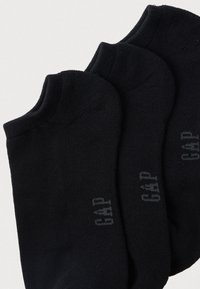 Sorte ankelsokker lavet af blødt stof med ribbet tekstur og diskret logodetalje på siderne. Tre par i forskellige størrelser.