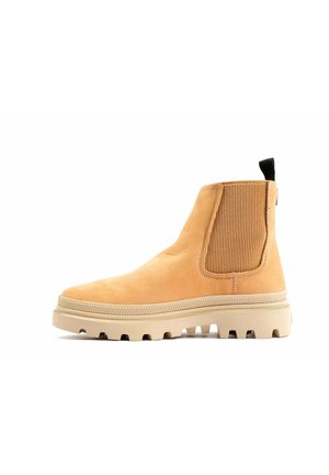 Beige Wildleder-Ankle-Boot mit elastischen Seiteneinsätzen, verstärktem Rückenzug und strukturiertem Gummisohle mit Profil für Rutschfestigkeit.