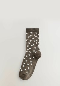 Braune Socken mit einer weichen Textur, die durchgehend mit einem weißen Herzmuster versehen sind und einen gerippten Bund oben haben.