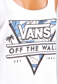 Camiseta sin mangas blanca con un gráfico triangular que presenta "VANS" en letras negritas y un diseño abstracto en azul y negro, incluyendo acentos de palmera.