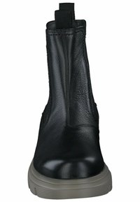 Botte noire en cuir à hauteur de cheville avec des panneaux latéraux en élastique, une pointe arrondie et une finition texturée. Dispose d'une semelle en caoutchouc grise et d'une languette.