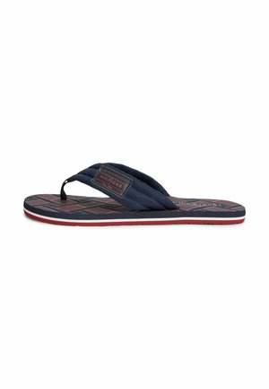 Navyblauer Flip-Flop mit rot und navy gemusterter Sohle, gepolstertem Stoff-Zehentrenner und einem rechteckigen Stoffmarkenlabel am Riemen.