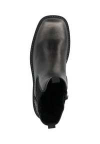 Botín de cuero negro hasta el tobillo con paneles laterales elásticos, puntera redonda y costuras decorativas. El forro interior es texturizado y cuenta con una lengüeta.