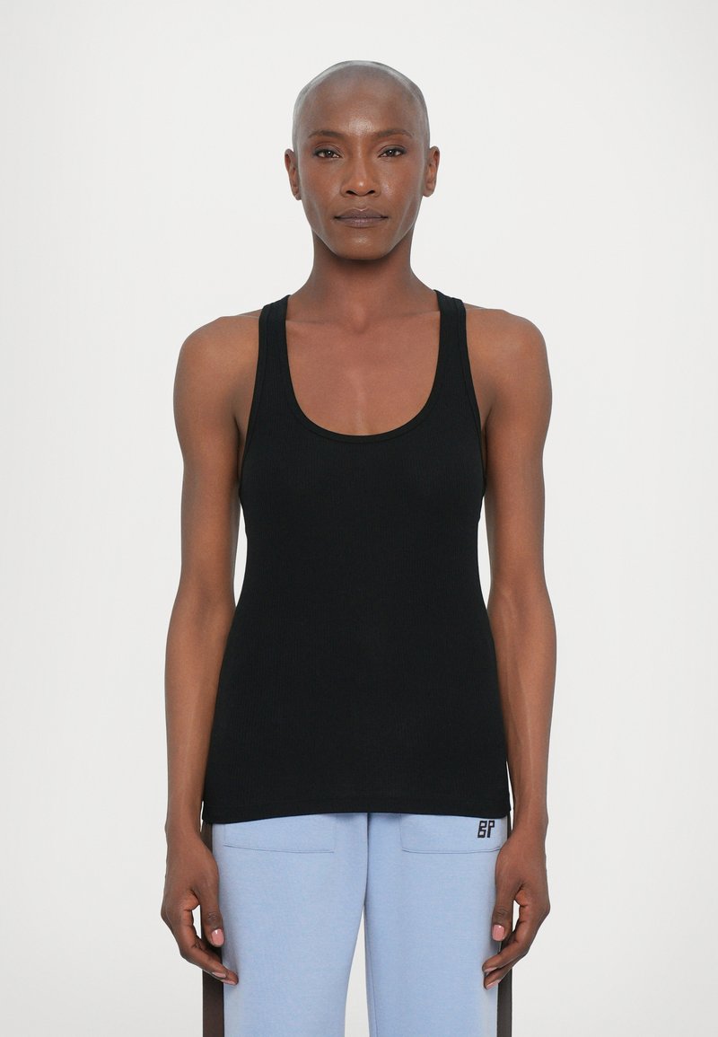Top negro de canalé con escote redondo, diseño sin mangas y silueta ajustada. Marca minimalista y sutiles aberturas laterales en el bajo.