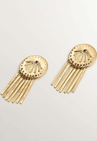 Pendientes en tono dorado con discos circulares que presentan diseños texturizados en forma de estallido solar y múltiples flecos de metal martillado colgantes.