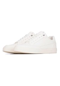 Sneakers bianchi realizzati in materiale liscio, con punte arrotondate, lacci piatti e un branding discreto sul tallone, accompagnati da una suola in gomma testurizzata.