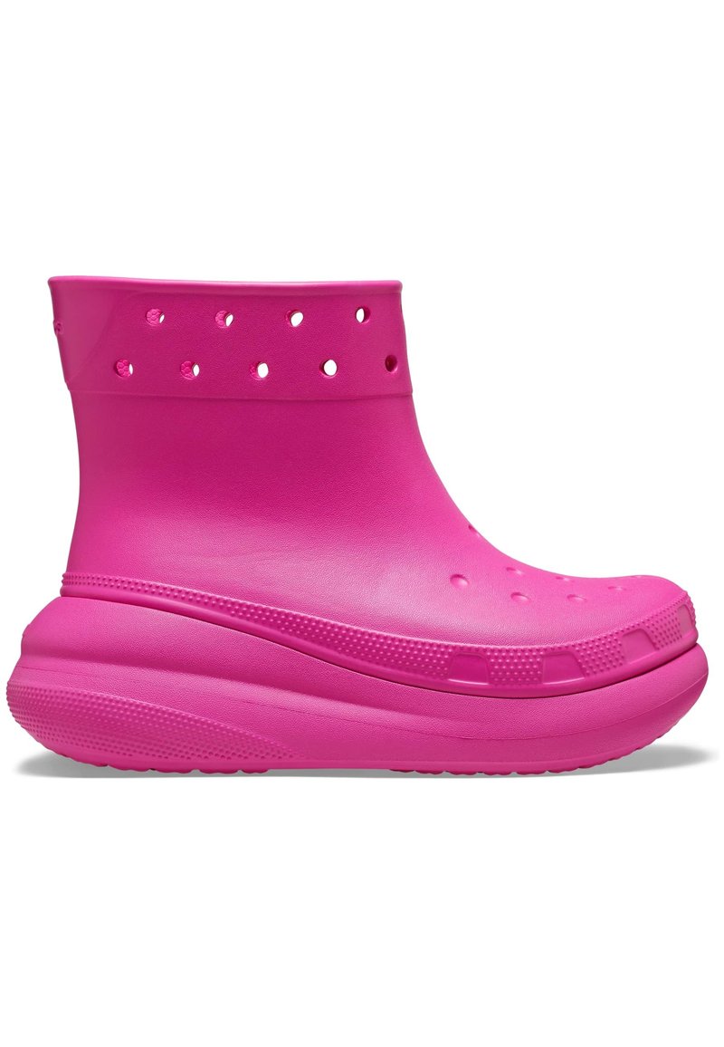 Rosa Stiefel in Knöchelhöhe aus glattem Gummi, mit Belüftungsöffnungen und einer strukturierten Sohle für besseren Halt. Abgerundete Zehenpartie und gepolsterte Ferse.