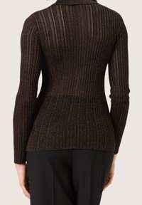 Svart ribbad topp med lång ärm, med en subtil metallisk glans. Skräddarsydd passform med rund halsringning och strukturerat mönster.