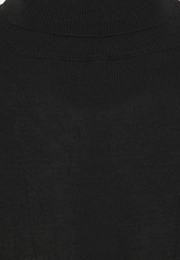 Pull à col roulé noir en tricot côtelé, avec un col haut et une texture lisse, au design ajusté.