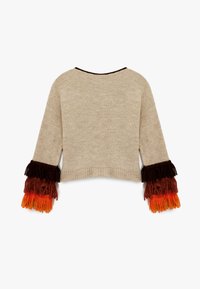 Pull en tricot beige avec des manches surdimensionnées et des détails en franges multicolores dans les tons de marron, orange et rouge. Conception cropped avec un col rond.