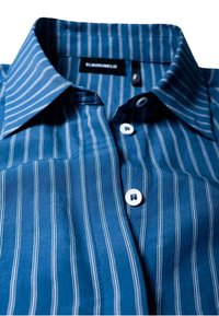 Niebieska koszula z pionowymi białymi paskami, białymi guzikami i kołnierzem rozpiętym, rozłożona płasko na białym tle.