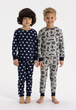 Two children wear pajamas: one in navy with white stars, the other in grey with vehicle patterns. Both have long sleeves and fitted pants.