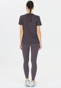 Harmaa urheilupaita ja siihen sopivat legginsit. Kangas näyttää sileältä ja joustavalta. Ominaisuuksiin kuuluu klassinen muotoilu lyhyillä hihoilla ja pyöreällä pääntiellä.