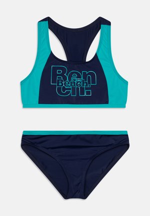 Tumedatest sinine bikiin komplekt, milles on värviblokeeritud kropp topp turkoosi aktsentidega ja suure "Bench." logoga, millele on sobitatud lihtne bikiini põhjaosa.
