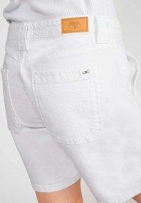 Witte denim shorts van een lichtjes textuurstof, met twee achterzakken, een leren merklabel en opgerolde zoom.