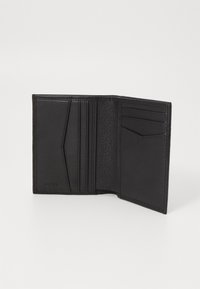 Portefeuille en cuir noir avec un intérieur texturé, plusieurs fentes pour cartes et un logo en relief. Design compact, plié en deux avec des bords lisses.
