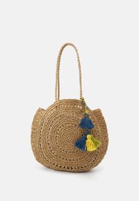 Sac en paille tissé avec un design circulaire, couleur brun clair, poignées en tresse doubles et trois pompons colorés avec des accents bleus et jaunes.