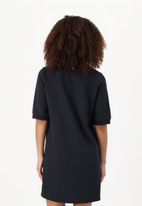 Marineblaues, kurzärmliges Kleid mit lockerer Passform. Glatte Textur, knielang und einfaches Design ohne Muster oder Verzierungen.