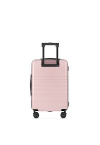 Hartschalenkoffer in Pink mit gerippter Oberfläche, schwarzen teleskopischen Griff und vier schwarzen Rollen für Mobilität. Seitenhandgriff für einfaches Tragen.