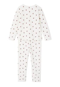 Long-sleeve pajama set in cream cotton, featuring a repeated pattern of small red fruits. Soft texture with an elastic waistband on pants.
