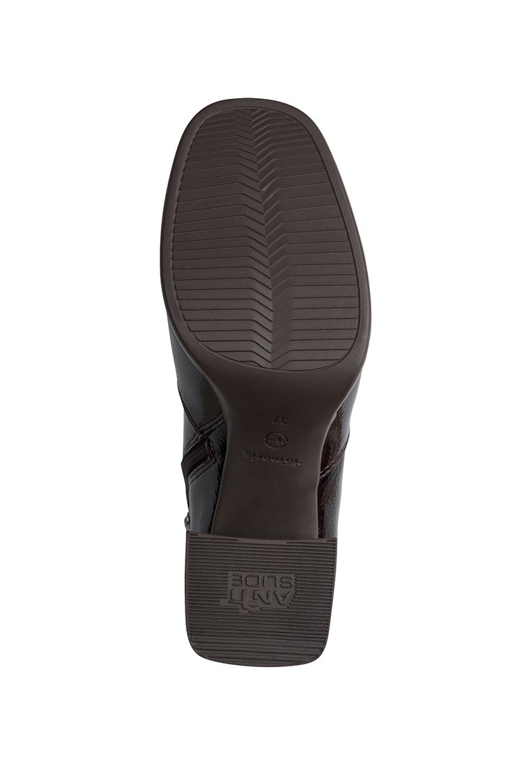 Scarpa di pelle marrone con superficie testurizzata, suola in gomma con motivo a spina di pesce e logo impresso. Tacco leggermente rialzato.