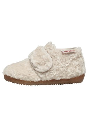 Chausson beige et moelleux avec une surface texturée, une sangle Velcro et une semelle en caoutchouc. Présente des détails de bord cousus et une étiquette portant la mention "NATURINO."